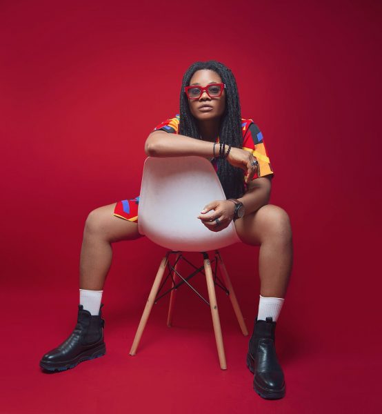 woman in glasses sitting backwards on a chair