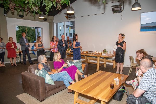 People listening to a speech; the speaker is on the right-hand side of the photo